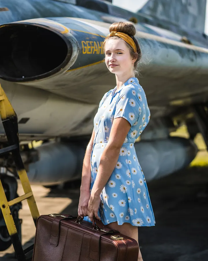 Mottoshooting: Schülerin mit Koffer vor einem Flugzeug